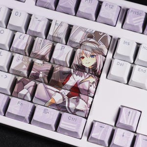 May include: A white mechanical keyboard with custom keycaps. The keycaps feature a light purple and white color scheme with an anime-style illustration of a female character with red and blue eyes. The keyboard has standard keys.