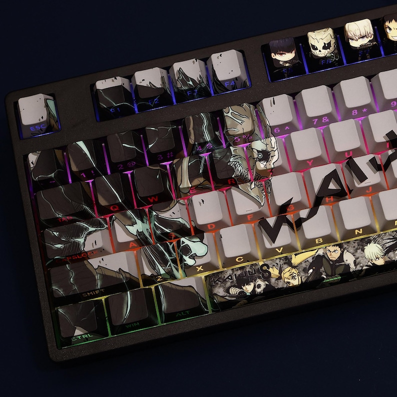 Op de afbeelding: Een zwart mechanisch toetsenbord met aangepaste keycaps met anime-achtige karakterkunst en abstracte ontwerpen. De keycaps zijn een mix van wit, zwart en grijs, met kleurrijke achtergrondverlichting zichtbaar.