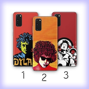 May include: Three phone cases with colorful illustrations. The cases feature portraits of a musician, with the text "DYLA" on one case and the quote "DON'T CRITICIZE WHAT YOU CAN'T UNDERSTAND" on another. The cases are red and orange.