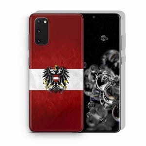 May include: A smartphone case featuring the Austrian flag design with a red and white horizontal background and a central black eagle emblem. The eagle holds a golden hammer and sickle in its talons, with a small red and white shield on its chest.