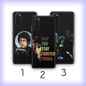 May include: Three black smartphone cases featuring Bob Dylan imagery. The first shows a portrait with a harmonica. The second displays a partial face with the text MAY YOU STAY FOREVER YOUNG. The third shows a silhouette with the text BOB DYLAN & HIS BAND.