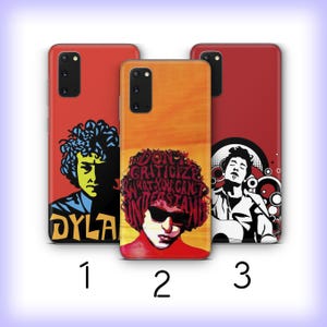 May include: Three phone cases with artistic designs. The first case is red with a blue and yellow illustration and the name "DYLA". The second case is orange with a portrait and the text "DON'T CRITICIZE WHAT YOU CAN'T UNDERSTAND". The third case is red with a black and white illustration.