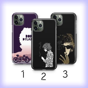 May include: Three phone cases with Bob Dylan-themed designs. The cases feature images of the musician, a motorcycle, and song lyrics. The cases are black, purple, and tan. The cases are numbered 1, 2, and 3.