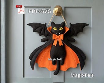 May include: A black felt cat wall hanging featuring bat wings, a bright orange cape lining, and an orange bow tie. The cat has yellow eyes and white fangs. The text PDF+SVG and MagixFelt are visible on the item. It hangs from a gold-coloured hook.