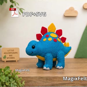 Può includere: Un peluche stegosauro in feltro blu con ventre giallo, macchie gialle e placche dorsali rosse e gialle. Il giocattolo presenta cuciture visibili lungo i bordi e occhi a bottone neri. Il testo sull'immagine include PDF+SVG, Little Adventurers Big Stories e MagixFelt.