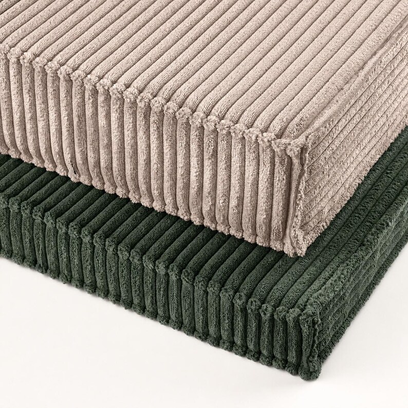 two rectangular cushions, one beige and one green, stacked on top of each other.