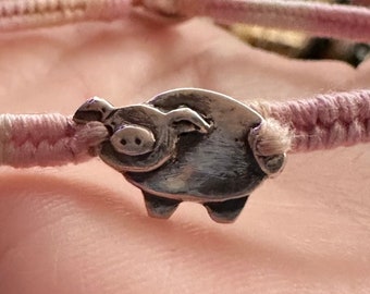 A tiny hand made fine silver piggie on a pretty pinks leather, sterling silver and cotton friendship bracelet...