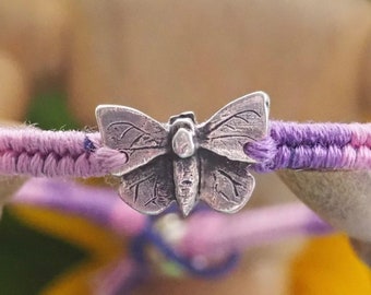 A lovely fine silver butterfly on a beautiful pinky purple leather, cotton and sterling silver friendship bracelet.