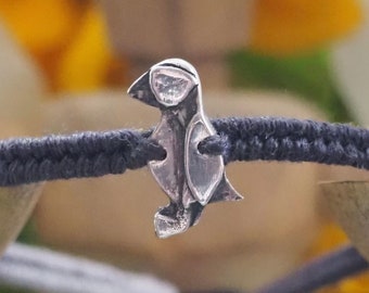 An adorable hand made fine silver puffin on a beautiful soft grey leather and cotton friendship bracelet...
