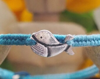 A gorgeous whale hand made in fine silver on a beautiful graduated blue cotton,leather and sterling silver friendship bracelet...