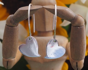 Delightful simple fine silver kicking heart earrings on handmade sterling silver wires.