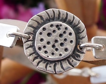 A simple fine silver sunflower set on a sterling silver bangle.