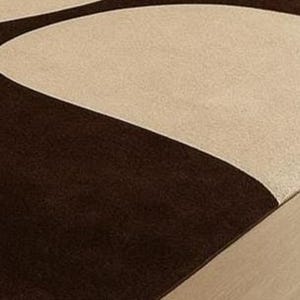May include: A modern area rug featuring a geometric design with a combination of brown and beige colors. The rug's pattern includes curved shapes, creating a contemporary aesthetic. The rug is placed on a wooden floor.