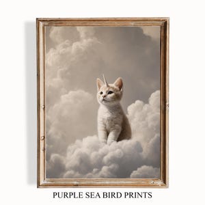 Könnte beinhalten: Gerahmter Druck mit einem Kätzchen mit einem Einhornhorn, das auf einer Wolke sitzt. Das Kunstwerk hat eine Vintage-Ästhetik mit einer weichen Farbpalette aus Beige und Weiß. Der Text "PURPLE SEA BIRD PRINTS" befindet sich unten.