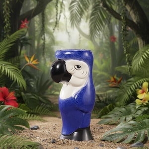 Può includere: Una tazza tiki a forma di pappagallo in ceramica blu con becco e base neri e dettagli bianchi. La tazza è ambientata su uno sfondo tropicale lussureggiante con un fogliame verde vibrante e fiori colorati.