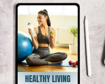 May include: A digital tablet displays a woman holding a water bottle and an apple, promoting a healthy lifestyle. The screen shows the text "HEALTHY LIVING planner". A blue exercise ball and red dumbbells are also visible.