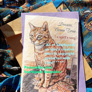 May include: A purple card with a drawing of a tabby cat sitting on a textured surface. The card has the text "Dream, Come True (a spirit's song)" and "All of heartspeak on etsy's creative work is copyright protected with love..." and "Personalize your heartspeak keepsake!"