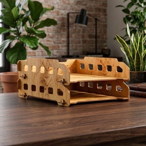 May include: A two-tier wooden document tray featuring a light brown wood grain finish and rectangular cutouts along the side panels. The desk organizer has a modular design with interlocking joints and a flat surface for storing papers.