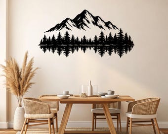 May include: Black metal wall art depicting a mountain range and a forest reflected in water. The artwork is mounted on a cream-colored wall above a wooden dining table with woven chairs, creating a nature-inspired theme.