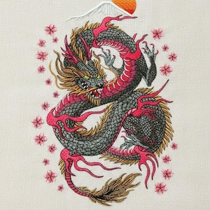 Può includere: Ricamo di un drago con corpo rosso e nero, circondato da fiori di ciliegio rosa. Il drago è arrotolato, con una montagna e un sole arancione sullo sfondo. Il disegno è su un tessuto color crema.