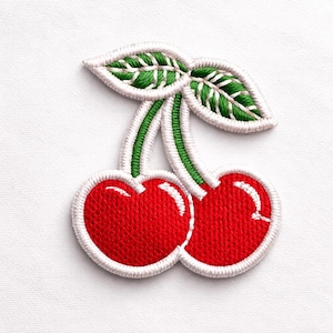 Può includere: Toppa ricamata raffigurante due ciliegie rosse brillanti con dettagli bianchi e un bordo bianco. I gambi sono verdi e le foglie sono verdi con dettagli bianchi. Perfetta per aggiungere un tocco fruttato a vestiti o accessori.