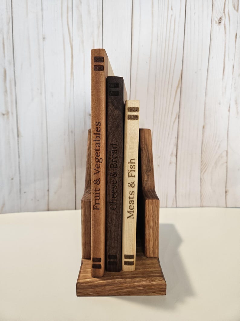 May include: A set of three ceramic mugs with a speckled, matte finish. The mugs are in shades of cream, light gray, and dark gray. Each mug has a simple, minimalist design and a rounded handle. The mugs are stacked on top of each other.