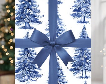 May include: A wrapped gift box featuring a blue and white Christmas tree pattern. The box is tied with a wide, navy blue ribbon and bow. The background is blurred, with a Christmas tree and lights visible.