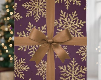 May include: A wrapped gift box with a deep purple background and gold glitter snowflake pattern. The box is tied with a brown satin ribbon and bow, creating a festive holiday presentation.