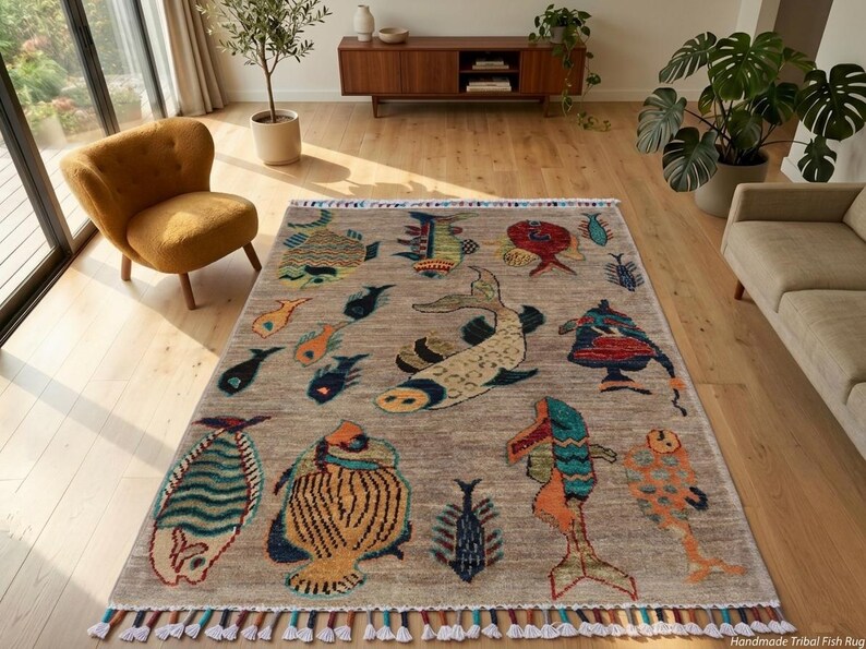 May include: A rectangular area rug with a light brown base featuring a variety of colourful fish illustrations in shades of blue, orange, yellow, and red. The rug has a fringed edge with multi-coloured tassels along the top and bottom borders.