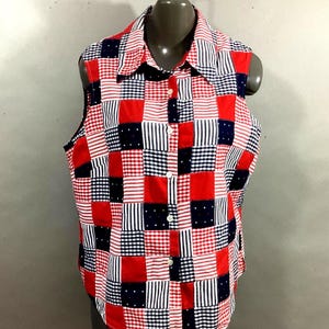 May include: A sleeveless patchwork shirt in red, white, and navy blue. The shirt features a collared neckline and a button-down front. The patchwork design includes squares of stripes, polka dots, and gingham patterns. The shirt is displayed on a mannequin.