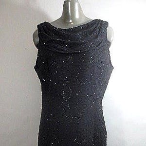 May include: A black sleeveless dress with a cowl neck and a sparkly texture.