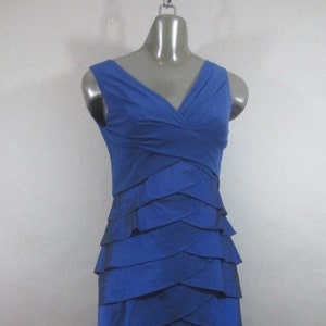 K&ouml;nnte beinhalten: Ein &auml;rmelloses Kleid in K&ouml;nigsblau mit einem mehrlagigen Rock und einem V-Ausschnitt.