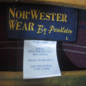 May include: A blue label with gold text that reads "Nor'Wester Wear By Pendleton" and "RN# 29685". The label also includes the text "Shell 60% Polyester 40% Wool", "Made in Mexico", "See Reverse for Care", and "L".