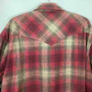 Puede incluir: Camisa a cuadros rojos, beige y marrones con un detalle de canes&uacute; puntiagudo en la espalda. La camisa tiene cuello abotonado y mangas largas. El estampado de cuadros es un dise&ntilde;o cl&aacute;sico.