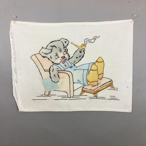 May include: A white fabric panel featuring a printed illustration of a grey bear wearing blue overalls, sitting in a chair with a footstool, smoking a pipe with visible smoke curls. The text "PILLOW TOP AND BACK" is printed on the left edge.
