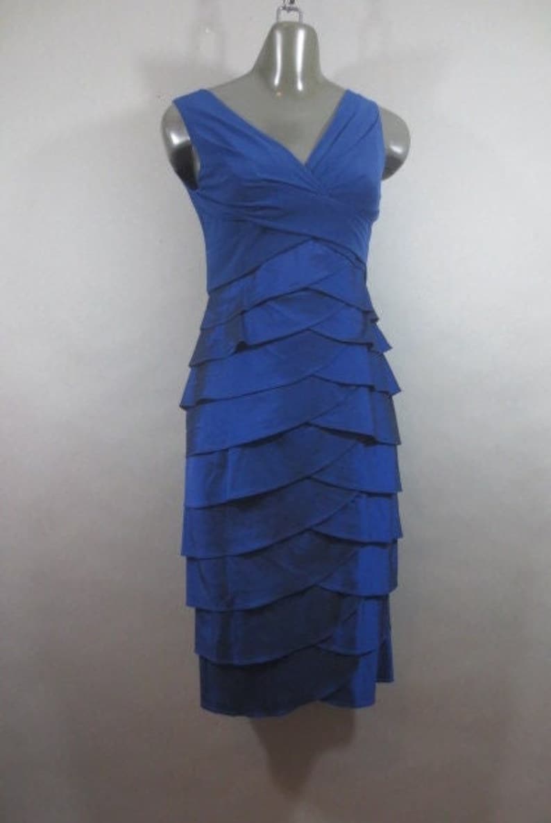 K&ouml;nnte beinhalten: Ein &auml;rmelloses Kleid in K&ouml;nigsblau mit einem mehrlagigen Rock und einem V-Ausschnitt.