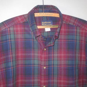 May include: A red, blue, and green plaid long-sleeve button-down shirt with the label "New Yorker Wear" on the collar.
