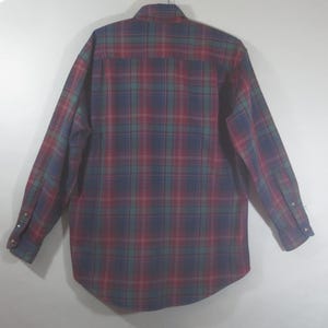 May include: A long-sleeved plaid shirt with a red, green, and blue plaid pattern. The shirt has a button-down collar and button cuffs.