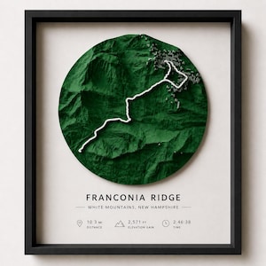 May include: A framed 3D topographic map of Franconia Ridge in the White Mountains, New Hampshire. The circular green terrain features a white trail path. Text includes: FRANCONIA RIDGE, WHITE MOUNTAINS, NEW HAMPSHIRE, 10.3 MI, 2,571 FT, 2:46:38.