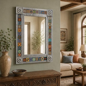 Puede incluir: Un espejo de pared rectangular con un marco de tono plateado, detalles metálicos decorativos en las esquinas y bordes verticales y horizontales incrustados con pequeños azulejos de cerámica coloridos y estampados en tonos azul, naranja, amarillo y verde.