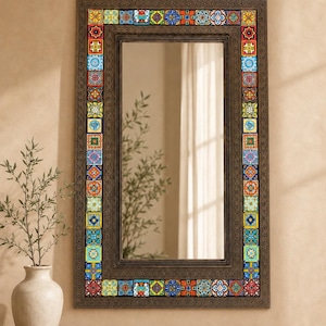 May include: A rectangular wall mirror featuring a dark brown frame decorated with a border of colorful, patterned square tiles. The tiles display various geometric and floral designs in shades of blue, red, yellow, green, and orange.