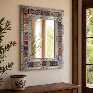 May include: A rectangular wall mirror featuring a metallic frame decorated with a border of colorful, patterned ceramic tiles. The tiles display various geometric and floral designs in shades of blue, red, orange, yellow, and green.
