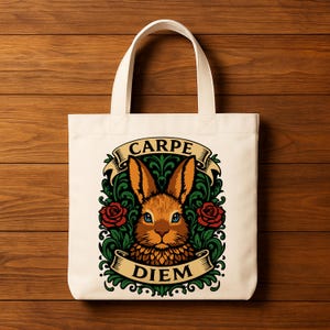 May include: Cream-colored tote bag featuring a detailed illustration of a rabbit with blue eyes, surrounded by green foliage and red roses. The words "CARPE DIEM" are displayed on banners above and below the rabbit.