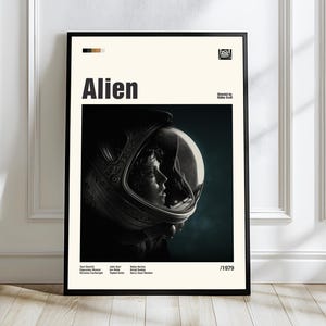 May include: Black framed movie poster for the film "Alien" featuring a profile of a person in a space helmet. The title "Alien" is in bold black letters. The poster includes the film's release year, 1979, and the 20th Century Fox logo.
