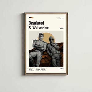 May include: A framed movie poster featuring Deadpool and Wolverine. The poster has a beige background with the title "Deadpool & Wolverine" in bold black text. The actors are in costume, with a sun graphic behind them. The poster is framed in a gold color.