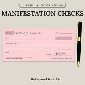 May include: A pink manifestation check with the text "MANIFESTATION CHECKS" and "The Bank of the universe." A black and gold pen is positioned to the right of the check. The check includes fields for date, pay, and memo.