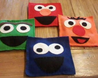 Juego de 4 saquitos de frijoles con forma de monstruos, para lanzar y jugar al Cornhole, ideales para fiestas de cumpleaños infantiles.