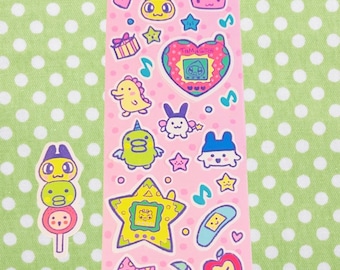 May include: A sheet of stickers featuring various cartoon characters and objects in pastel colors. The stickers include hearts, stars, musical notes, and a Tamagotchi device. The text "Silly Tamagotchi" is at the top.