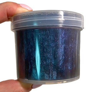 May include: A clear plastic container filled with dark blue slime with iridescent glitter.