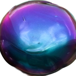 May include: A round, iridescent, metallic paint sample with a purple, blue, and green color shift.